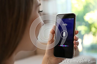 Woman using voice search on smartphone indoors Stock Photo