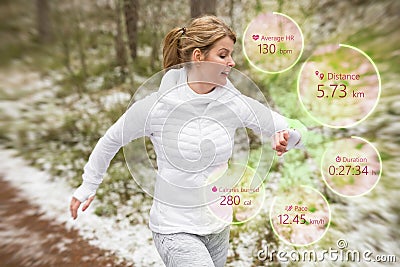 Woman using wearable tech during running workout outdoors Stock Photo