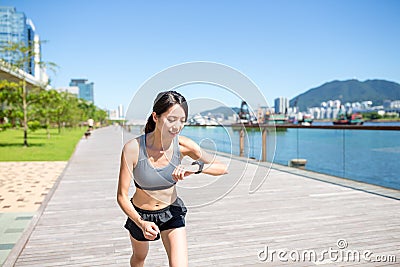 Woman using wearable watch when running Stock Photo