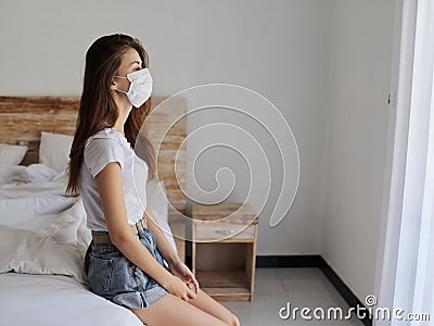 woman on vacation sitting on bed indoors shelf medical mask Stock Photo