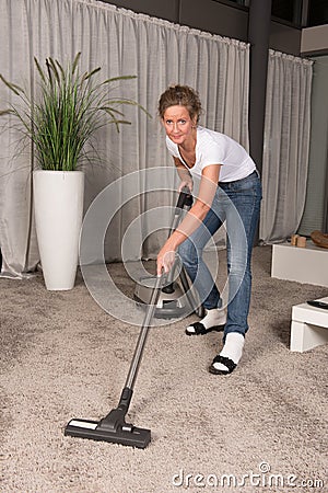 Woman vacuum cleaning carpet Stock Photo