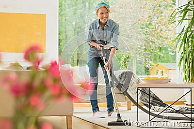 Woman is vacuuming beige carpet Stock Photo