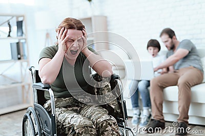 Woman veteran in wheelchair returned from army. A woman in a wheelchair is in pain. She`s in military uniform. Stock Photo