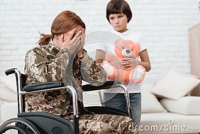 Woman veteran in wheelchair returned home. The son is happy to see his mother after returning from the army. Stock Photo