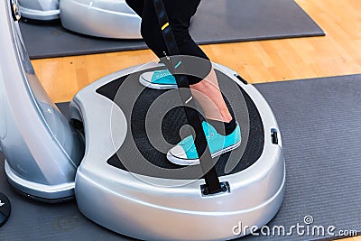 Woman on vibrating plates in gym training Stock Photo