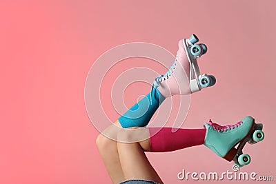 Woman with vintage roller skates on color background Stock Photo