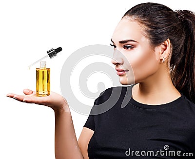 Woman with vitiligo presenting cosmetic primer oil for beauty. Stock Photo