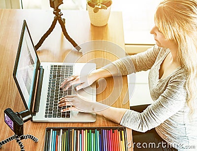 Woman vlogger editing photos and video for her blog with laptop - Girl filming her job for sharing on internet - New online work Stock Photo