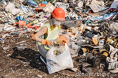 Woman volunteer helps clean the field of plastic garbage Editorial Stock Photo