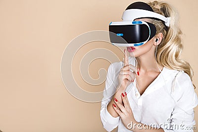 Woman with VR glasses of virtual reality. Young girl in virtual augmented reality helmet. VR headset. Stock Photo