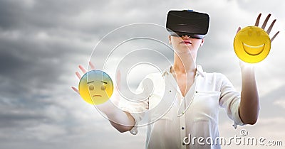 Woman in VR with network and emojis with flares against cloudy sky Stock Photo