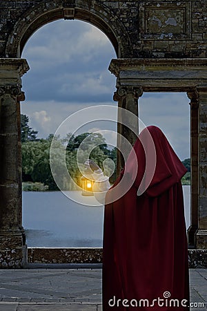 Woman waiting by lake with lantern Stock Photo