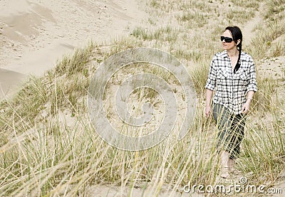 Woman walking alone in sand dunes Stock Photo