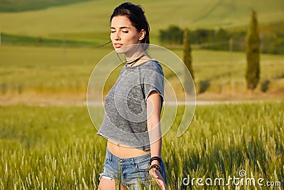 Woman is walking along the road among the fields Stock Photo