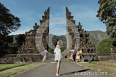 Woman walking through bali traditional gate Stock Photo