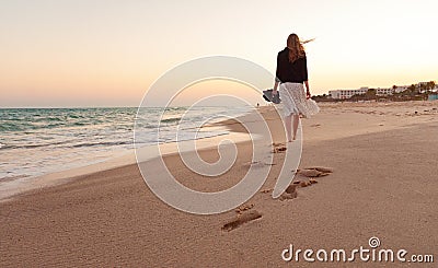 Woman walking beach sunset Stock Photo