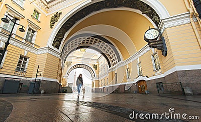 Woman walking with dog along street against facade of old buildings in downtown Stock Photo