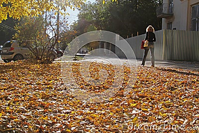 A woman is walking down the street in the fall in Volgograd Editorial Stock Photo