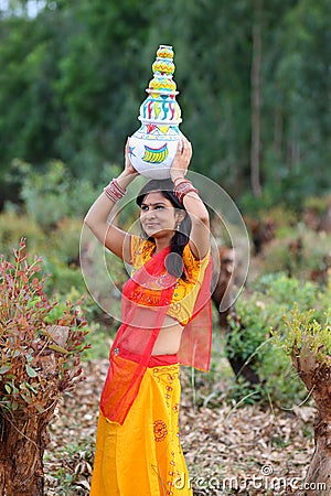 Woman walking with earthen pots Stock Photo