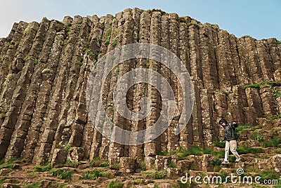 Woman walking among hexagonal stones at Giant`s Causeway Stock Photo