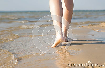 Woman walking on sand beach leaving footprint in the sand. Beach travel Stock Photo