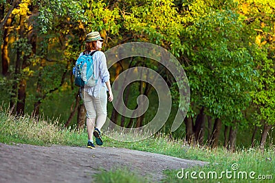 Woman walking on Trail in wild Forest at Sunset light Stock Photo