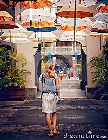 Woman walking under umbrellas in sunny tropical street Editorial Stock Photo