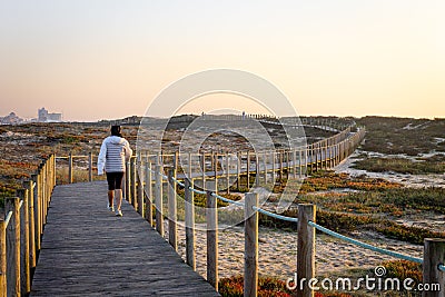 Woman Walks on Boardwalk Editorial Stock Photo