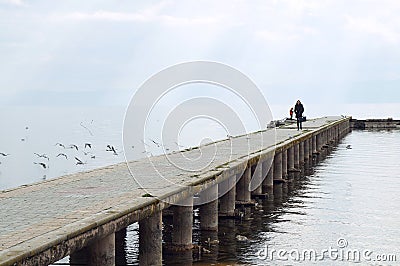 Woman walks on the pier of Ohrid lake, blurred Editorial Stock Photo