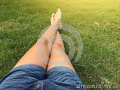 Woman ware short jean sitting on the green grass Stock Photo