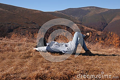 Woman in warm clothes relaxing on slope Stock Photo