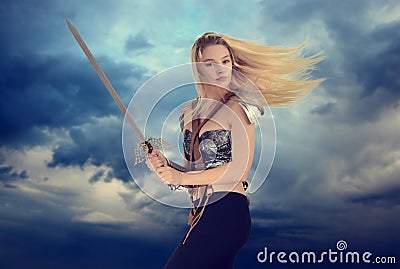 Woman warrior with cloudy sky background Stock Photo