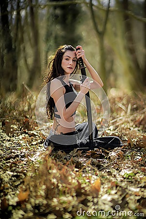 Woman Warrior Holding a Katana Sword, in Mystic Forest Stock Photo