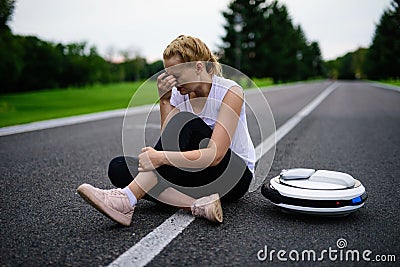 The woman was driving along the park path on the monocycle and fell. It hurts Stock Photo