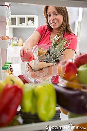 Woman was in purchase and full fridge with healthy food Stock Photo