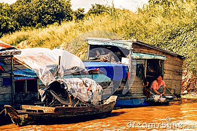 Woman wash dishes in floating house on Tonle Sap lake Editorial Stock Photo