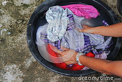 Woman wash hands dirty clothes in the basin black for cleanse Stock Photo