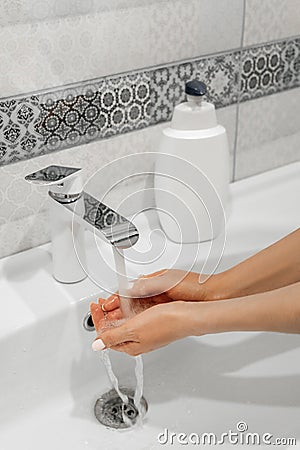 Woman washes her hands in the bathroom with special soap. Personal care and hygiene. Stock Photo