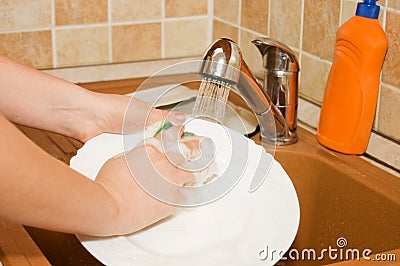 The woman washes ware on kitchen Stock Photo