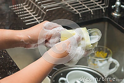 A woman washing stainless spoon by dish soap Stock Photo