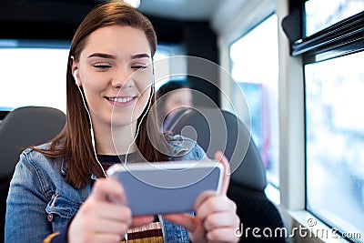 Woman Watching Movie On Mobile Phone During Journey To Work Stock Photo