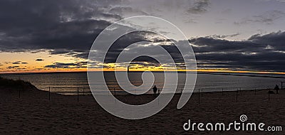 light house is glowing bright in fire skies of sunset on the bay Stock Photo