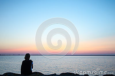 Woman watching bridge at sunset Stock Photo