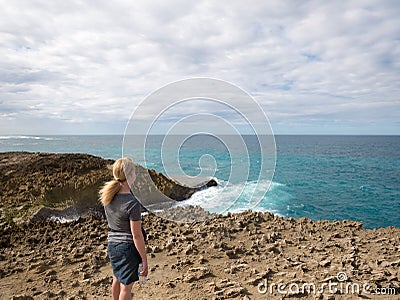 A woman is watching Huge waves collide against a reef near Jobos Beach in Puerto Rico, USA Stock Photo