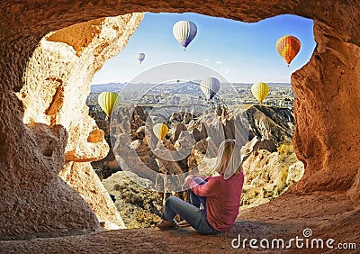 Woman watching like colorful hot air balloons flying over the valley at Cappadocia Stock Photo