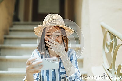 Woman watching an online movie on her phone Stock Photo