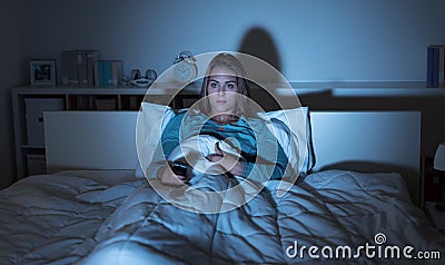 Woman watching tv in bed Stock Photo