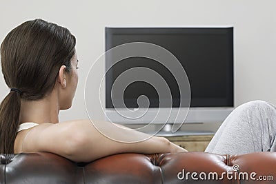 Woman Watching TV In Living Room Stock Photo