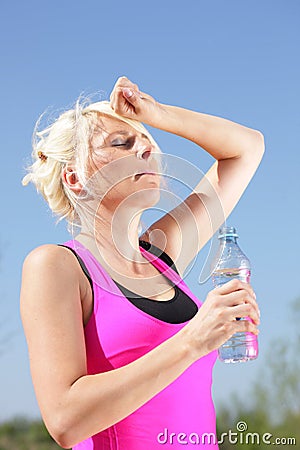 Woman with water bottle feels the heat of summer Stock Photo