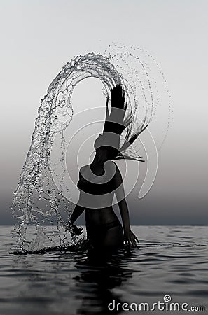 Woman in water waving hair. Stock Photo